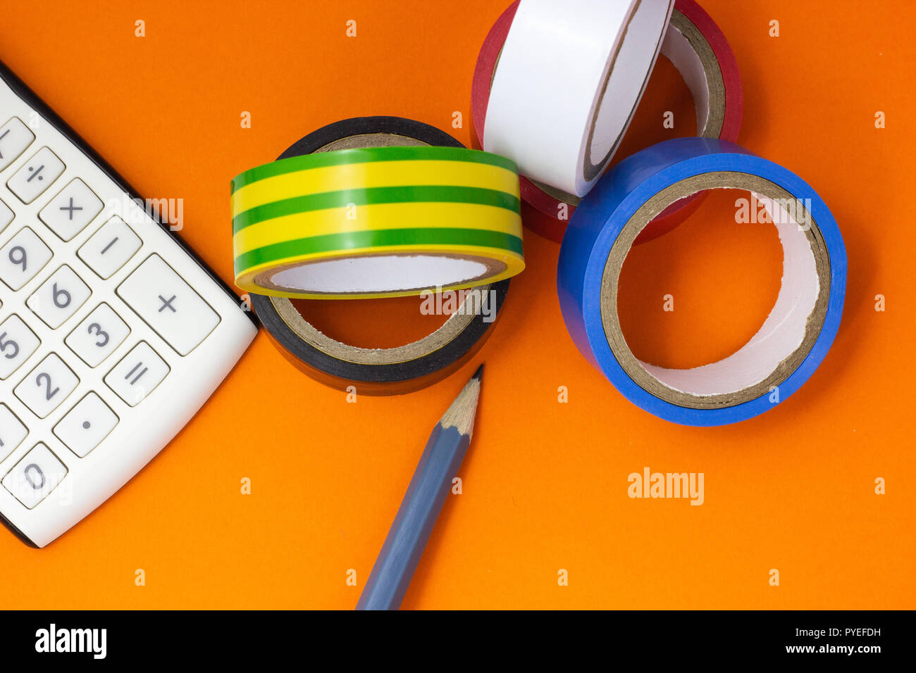 Calculator, insulating tape and pencil on an orange background Stock Photo