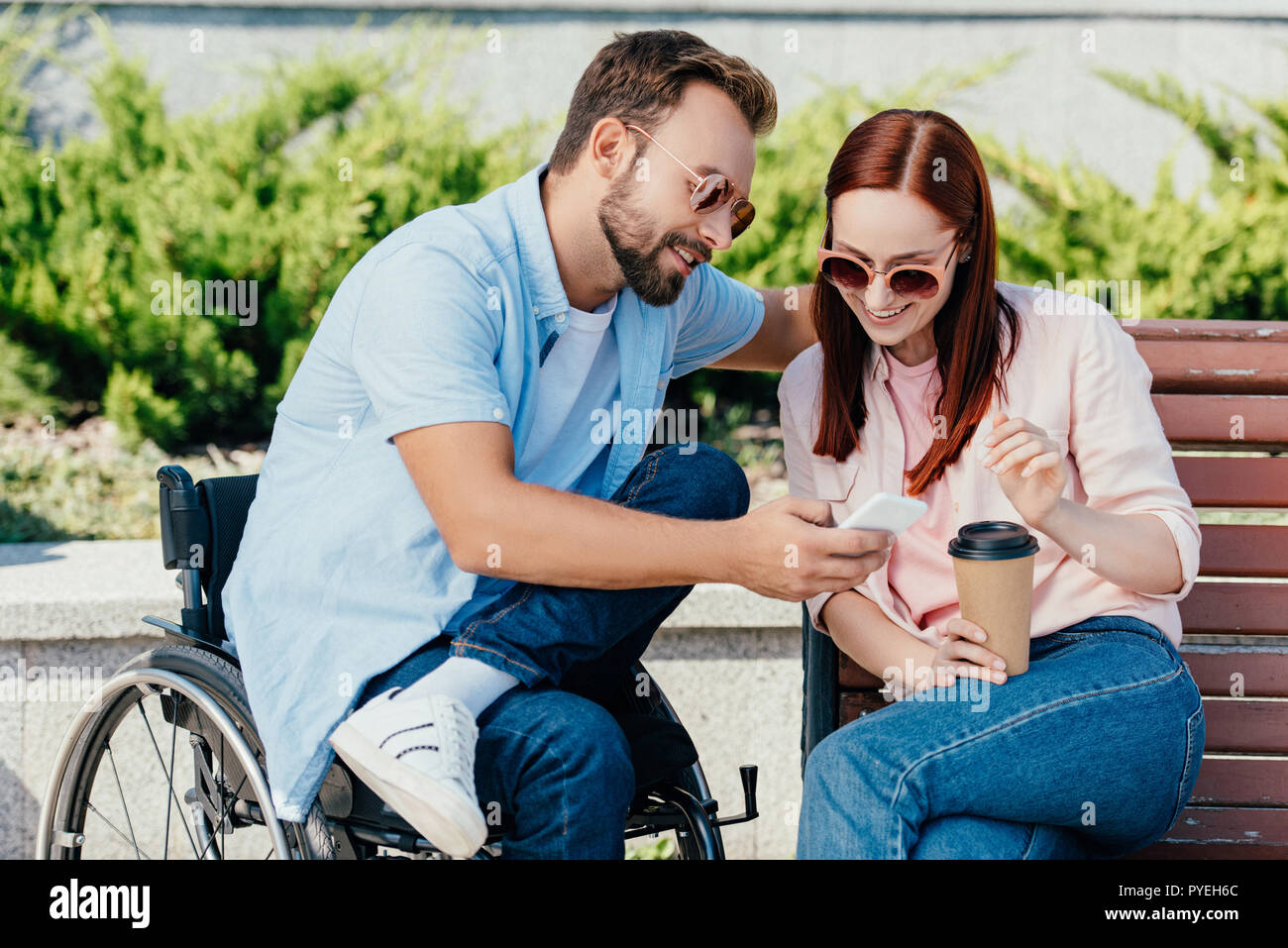 happy handsome boyfriend in wheelchair and girlfriend
