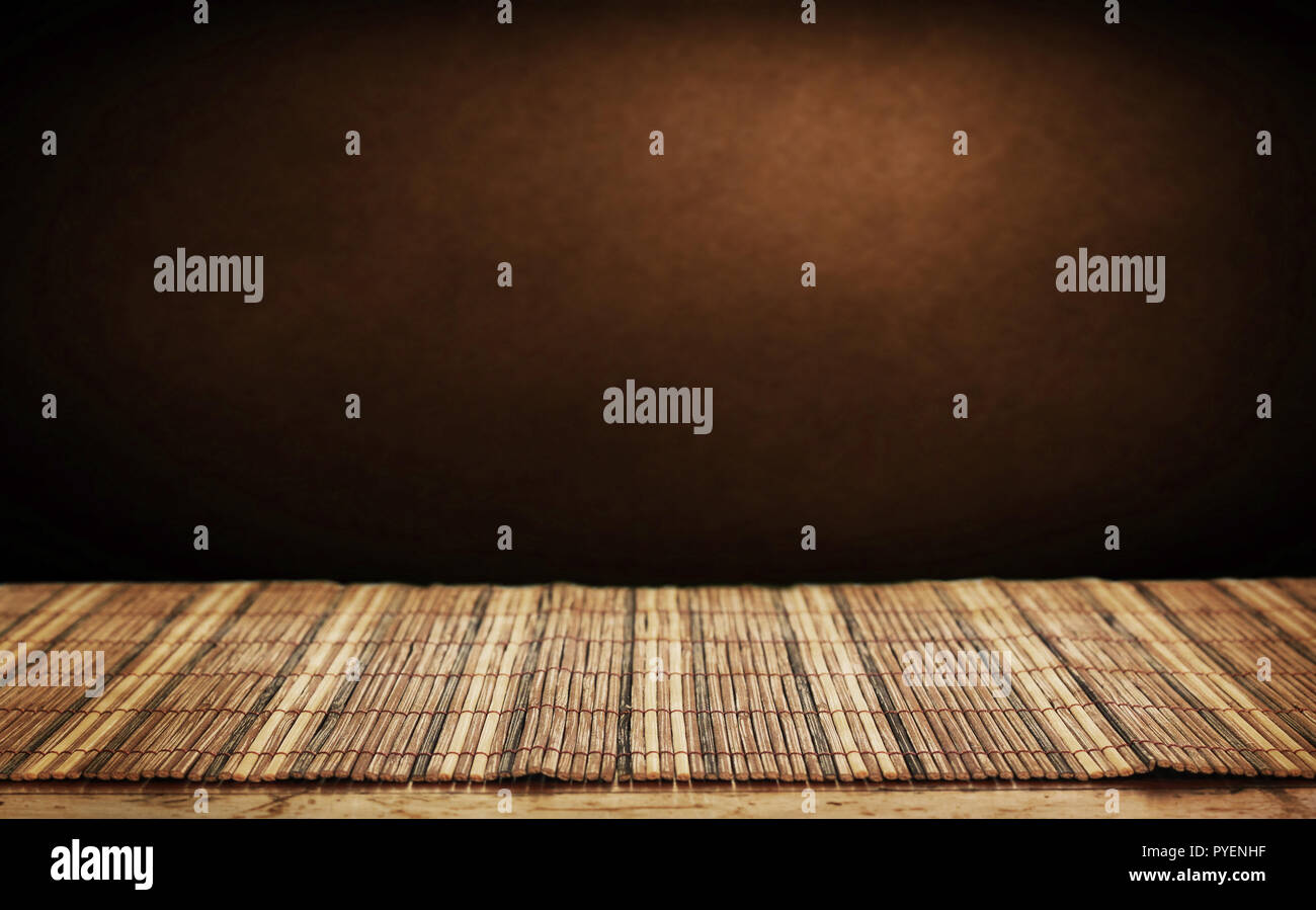 Empty bamboo table and green wall in background. Stock Photo