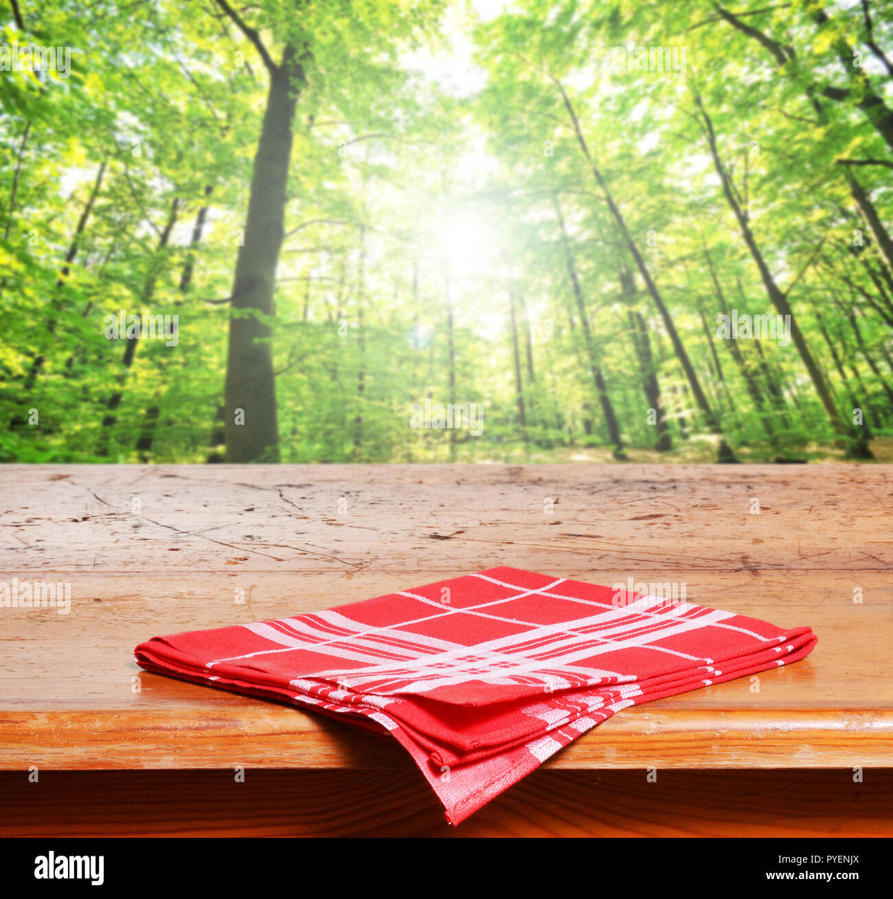 Empty wooden table and green forest in background Stock Photo - Alamy