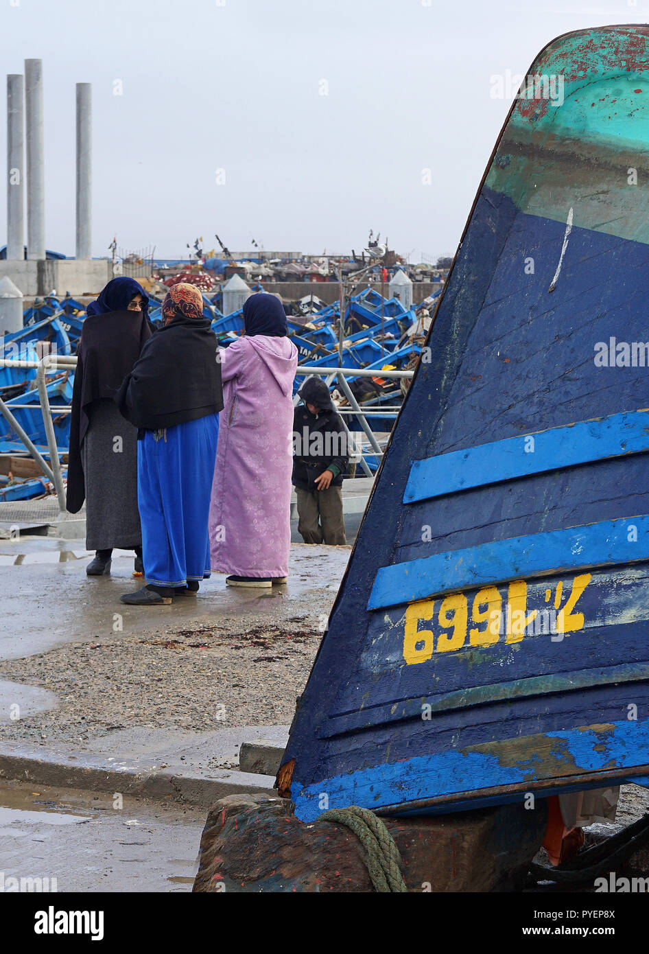 Women in traditional clothes having a chat in the fishing harbour of Essaouira, Morocco. Stock Photo