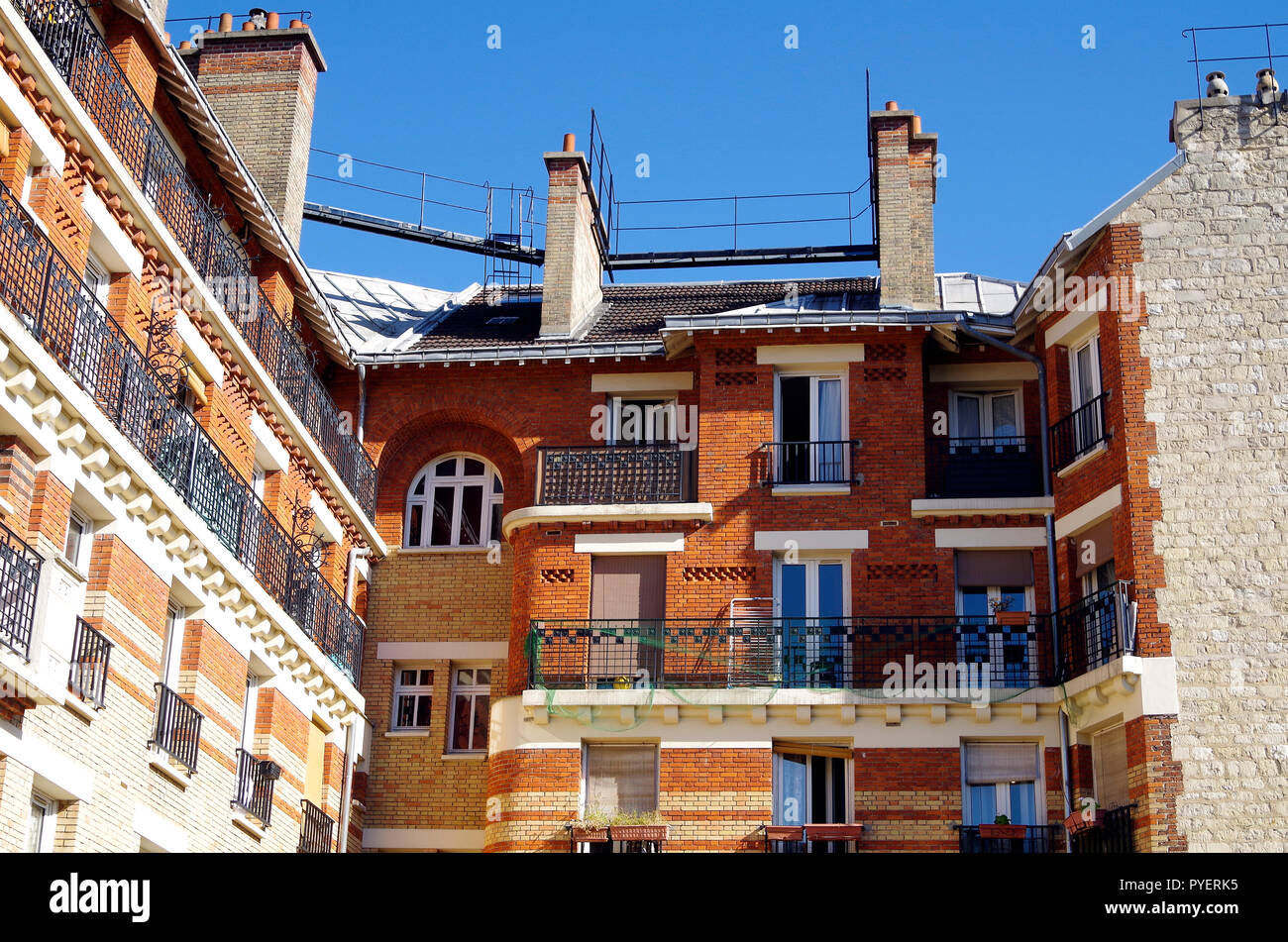 Paris, France, details of late 19thC apartment building finished in yellow & red brickwork, rough-cast stone, with elegant wrought iron balconies Stock Photo