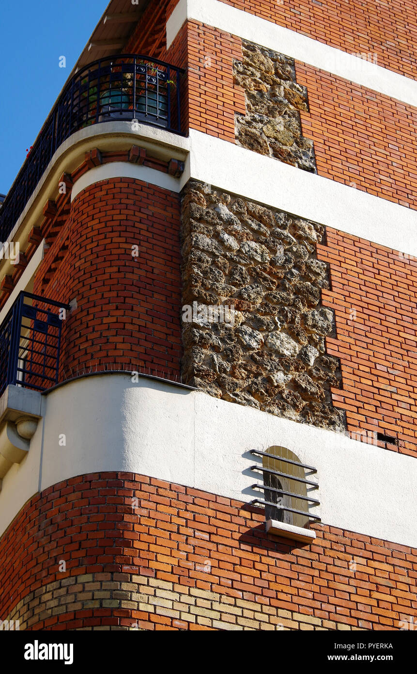 Paris France details of late 19thC apartment building finished in yellow red brickwork rough cast stone with elegant wrought iron balconies Stock Photo Alamy