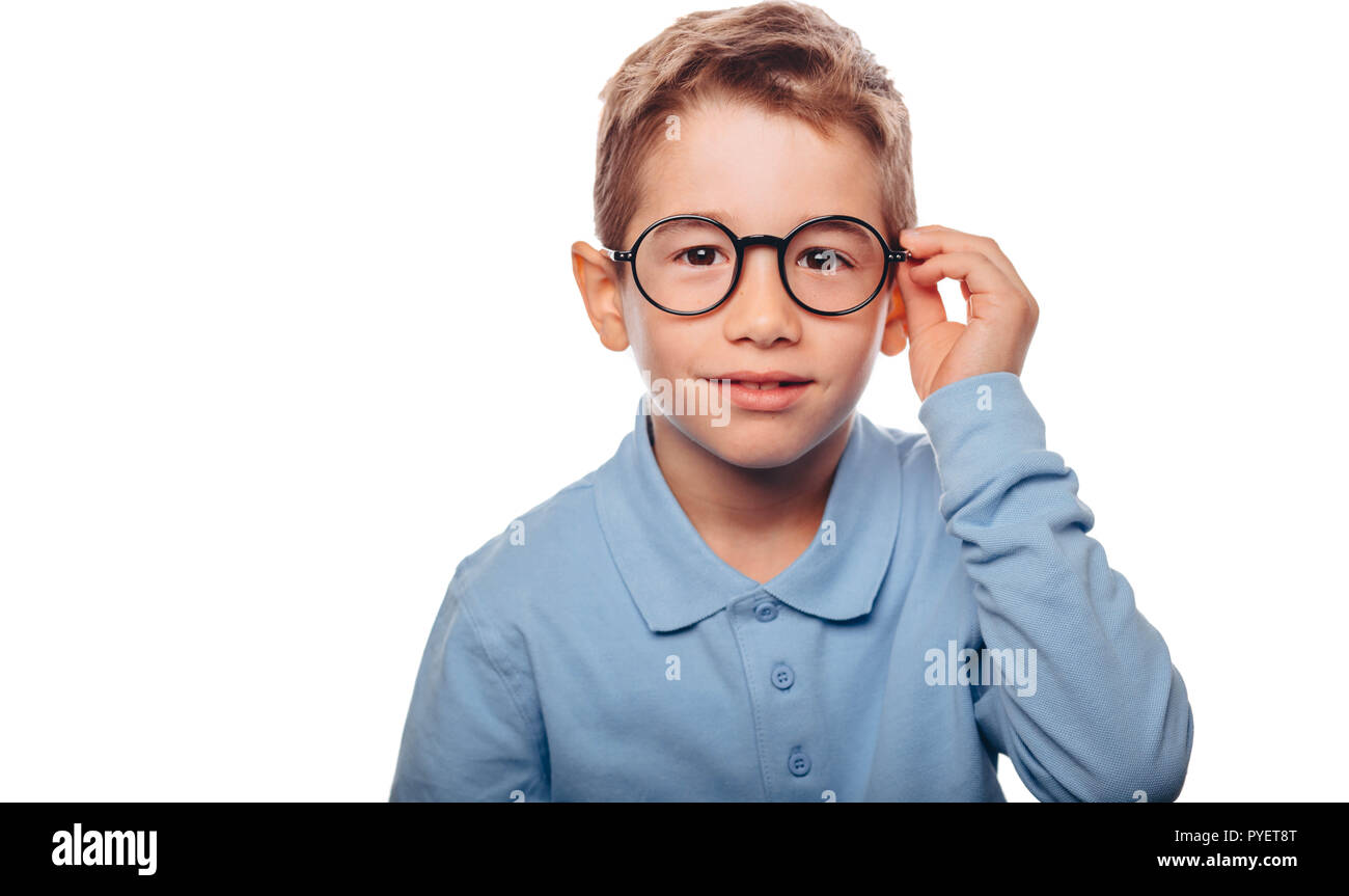 cucasian boy ajusting his eyeglasses and looking at camera over white background. Concept new eyeglasses for good vision Stock Photo