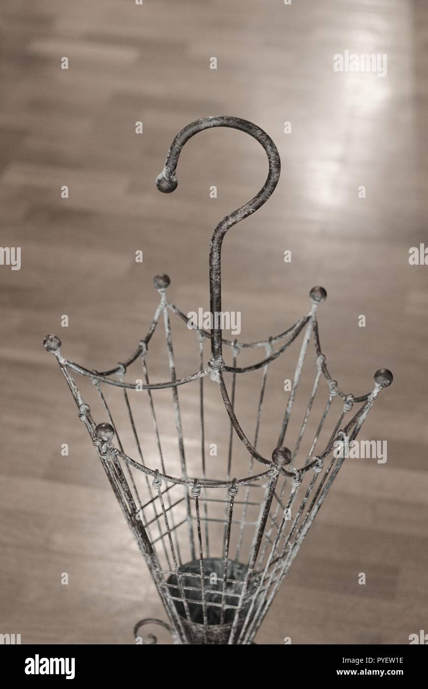 Vintage wrought iron umbrella stand with parquet background (Italy, Europe Stock Photo Alamy