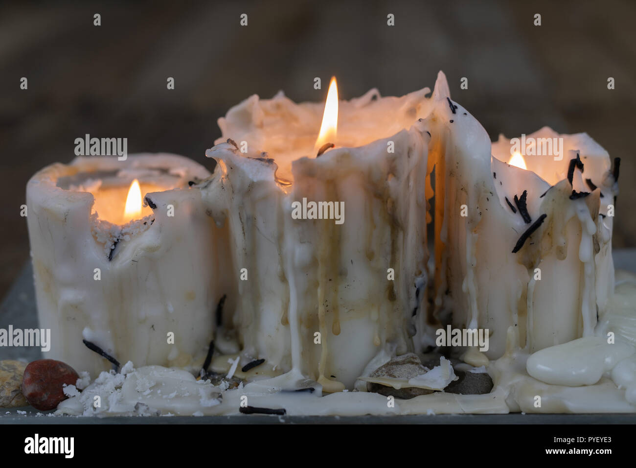 Old candles with dirty wax on a wooden table. Burning dirty
