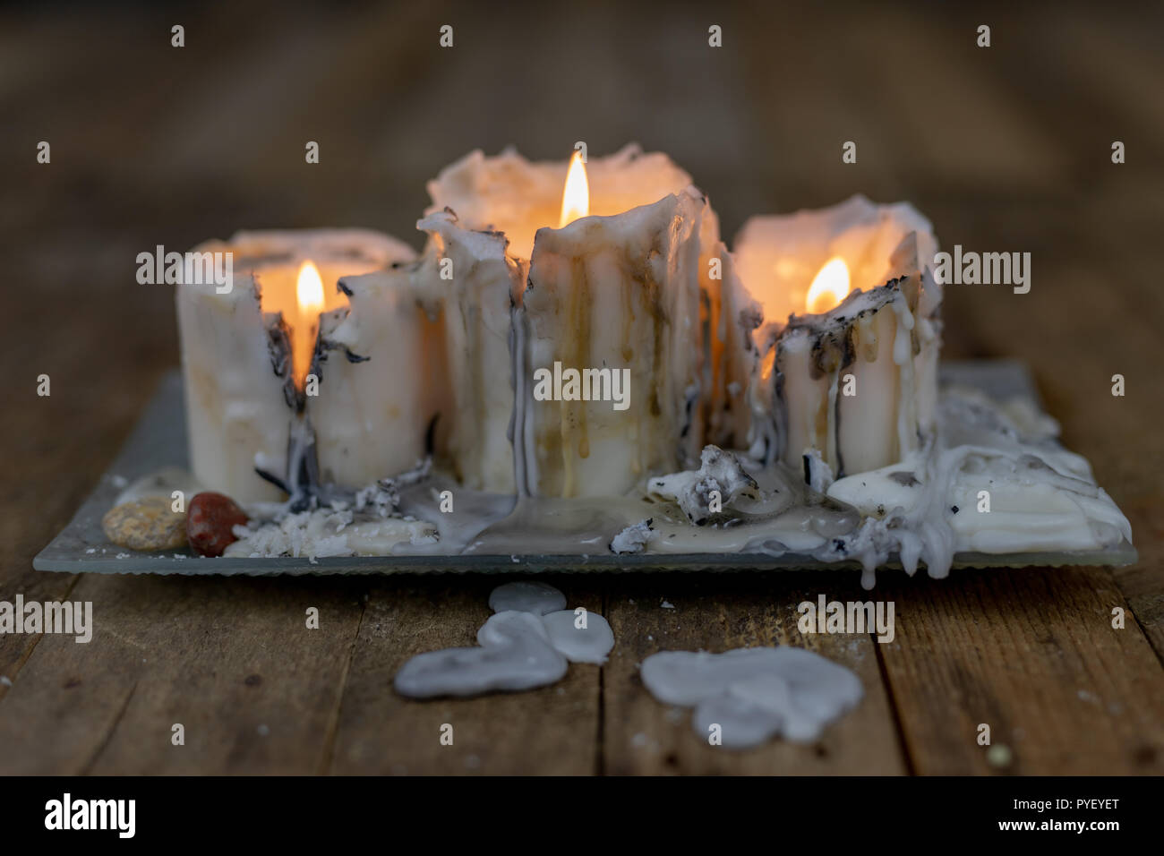 Old candles with dirty wax on a wooden table. Burning dirty