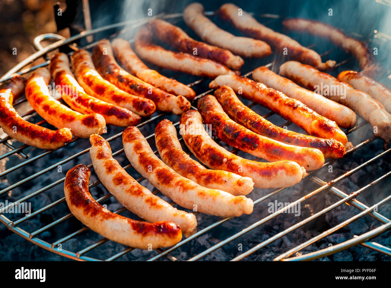 BBQ with fiery sausages on the grill outdoor picnic. Spending time together  with the family at the grill. Social meetings, friends. Juicy and well-grilled  sausages Stock Photo - Alamy