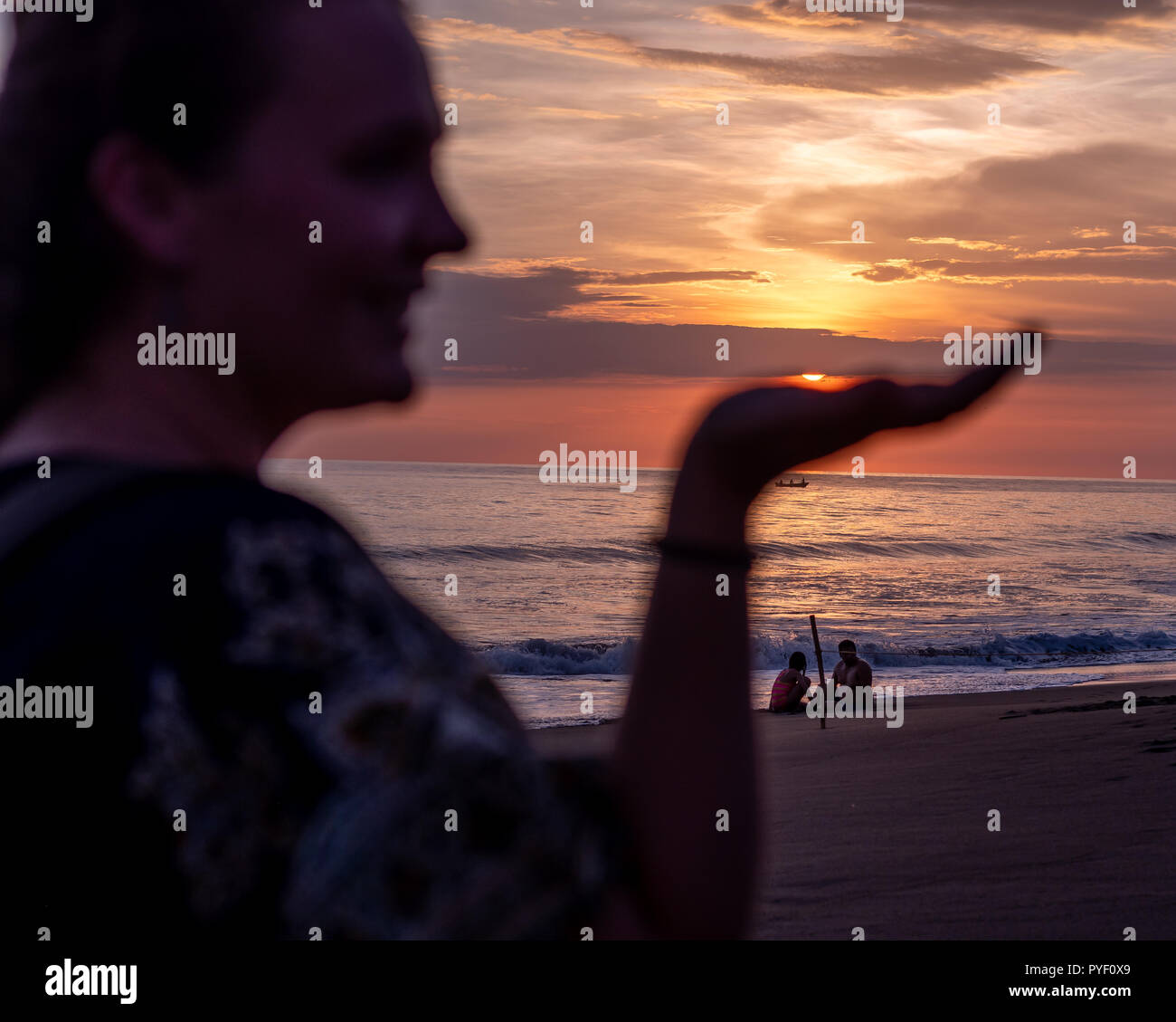 woman holding sun in Monterrico beach Guatemala Stock Photo