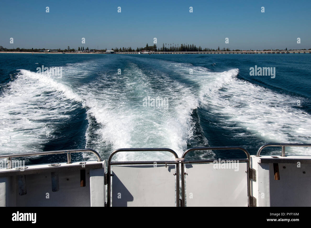 Busselton Australia, wake of motor boat with jetty and shore in