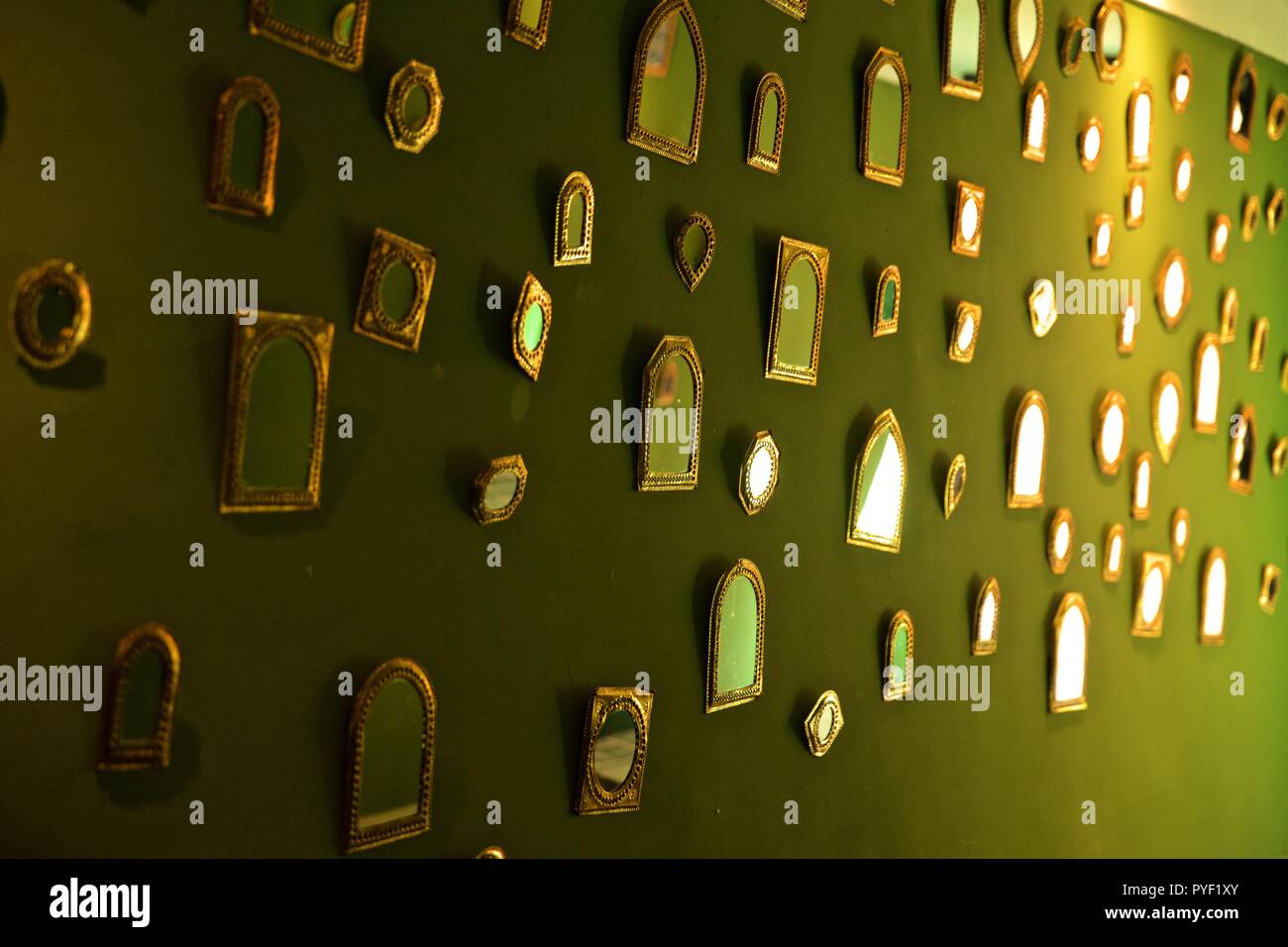 Mirrors on green wall Stock Photo - Alamy