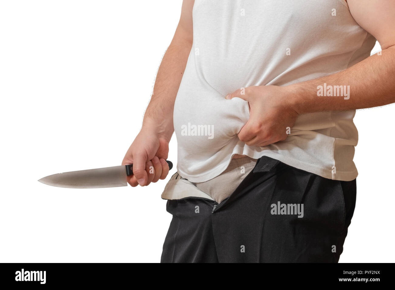 A man with one hand holds the fat fold on his big belly, and in the other hand holds a knife, as if wanting to remove it. Stock Photo