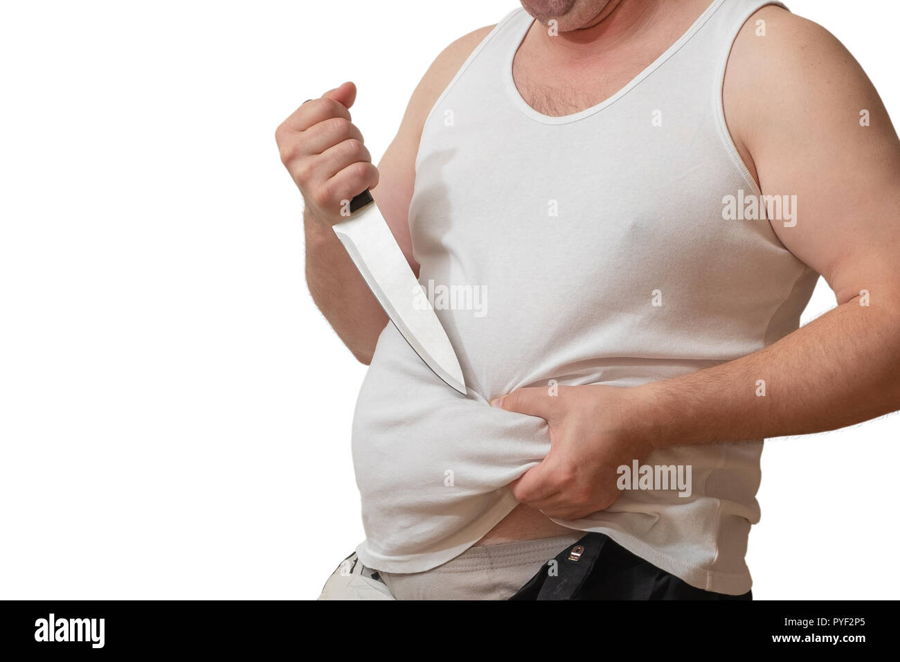 A man with one hand holds the fat fold on his big belly, and in the other hand holds a knife, as if wanting to remove it. Stock Photo