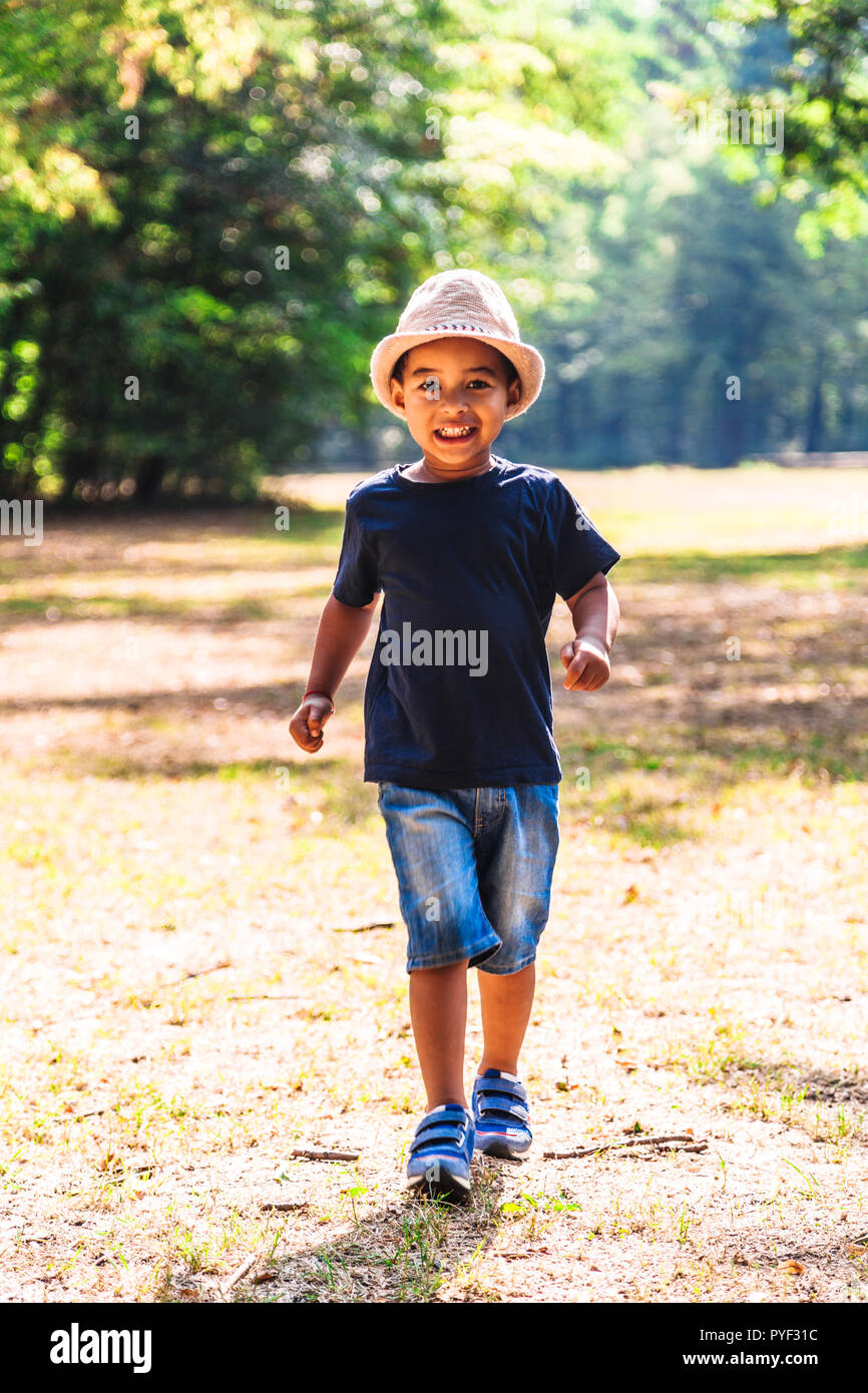 Close up portrait of little boy running outdoors in park Stock Photo ...
