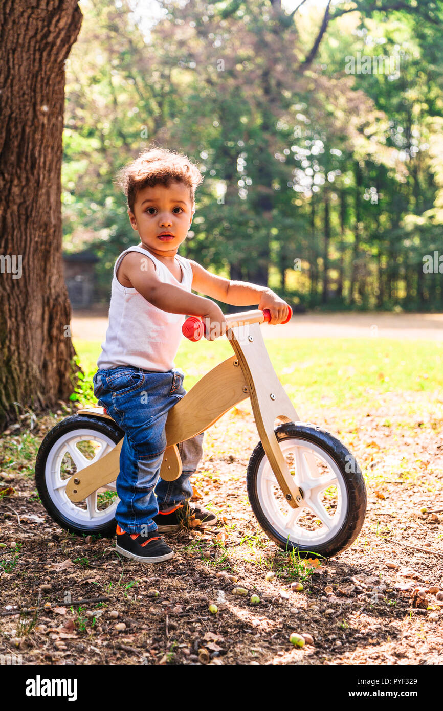 Afro-american or latin little boy ride bicycle in park Stock Photo