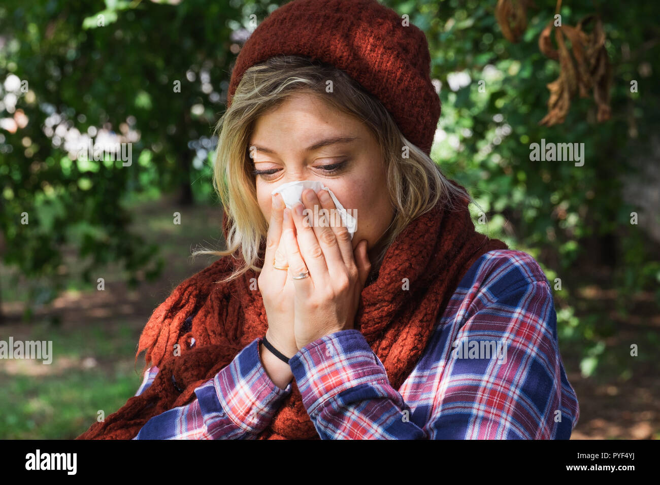 Woman portrait outdoor sneezing because cold and flu Stock Photo