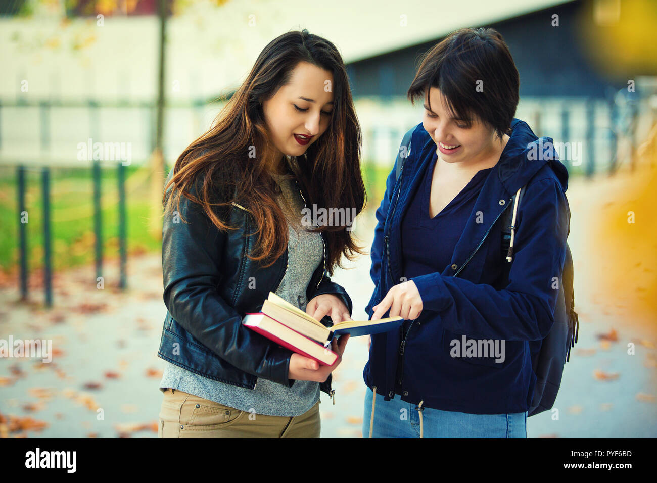 Two Cheerful Young Women Students Pointing Finger To A Book Finding The Correct Answer For Their Question Education As Solution To Life Problems Tea Stock Photo Alamy
