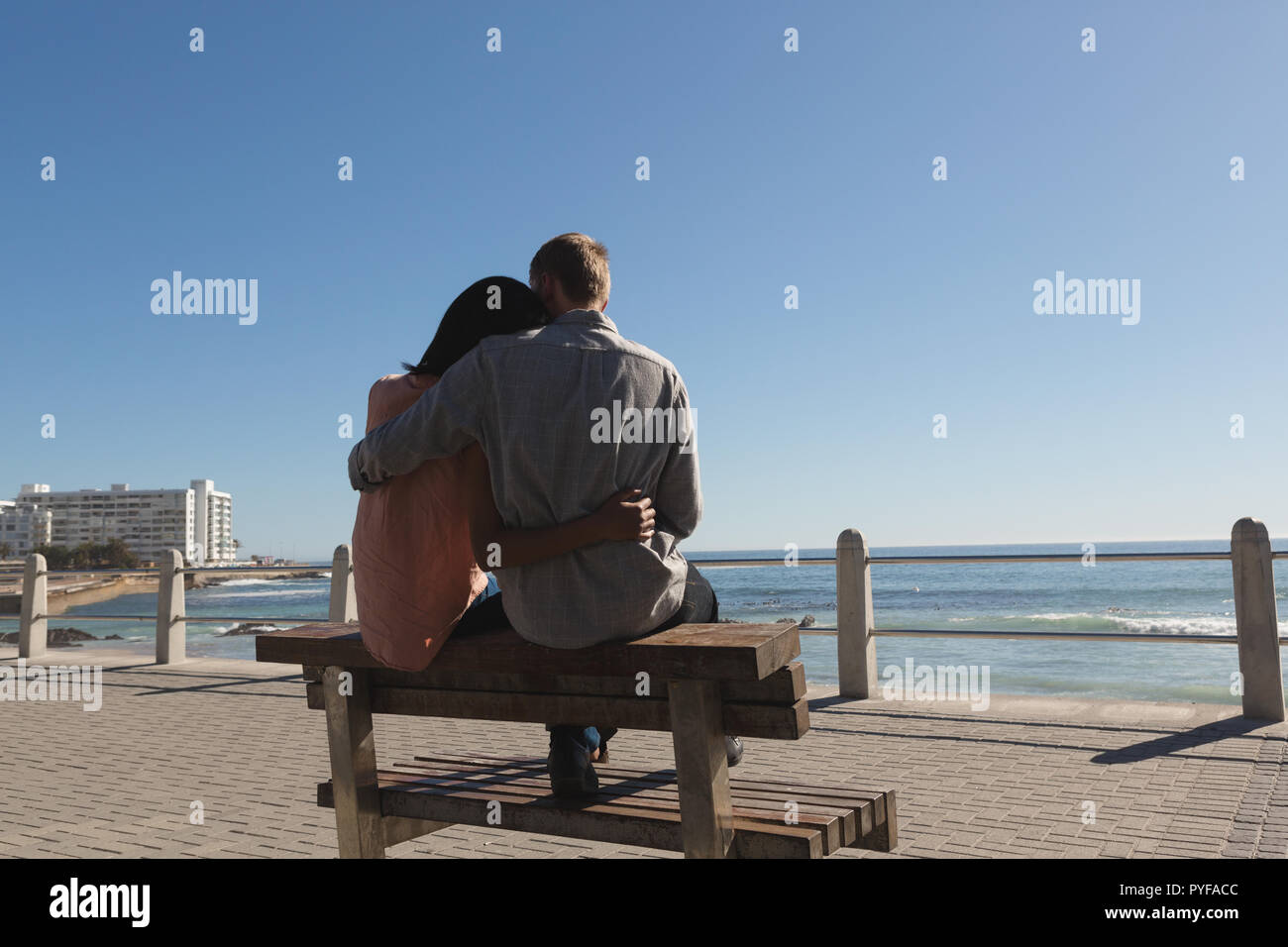 Couple sitting on bench near beach Stock Photo - Alamy