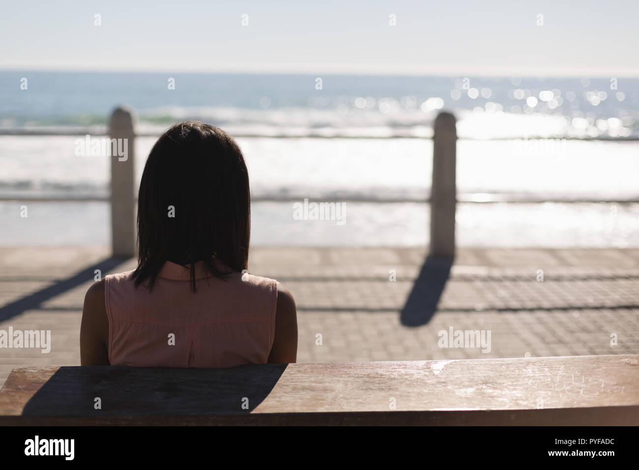 Woman sitting on promenade near beach Stock Photo - Alamy