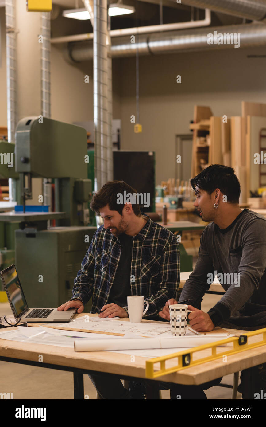 Two craftsman using laptop in workshop Stock Photo