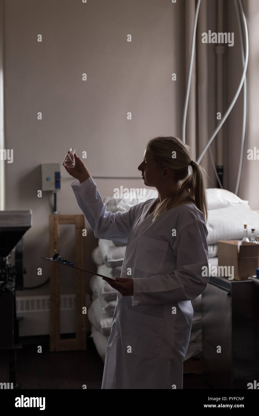 Female worker checking quality of gin Stock Photo