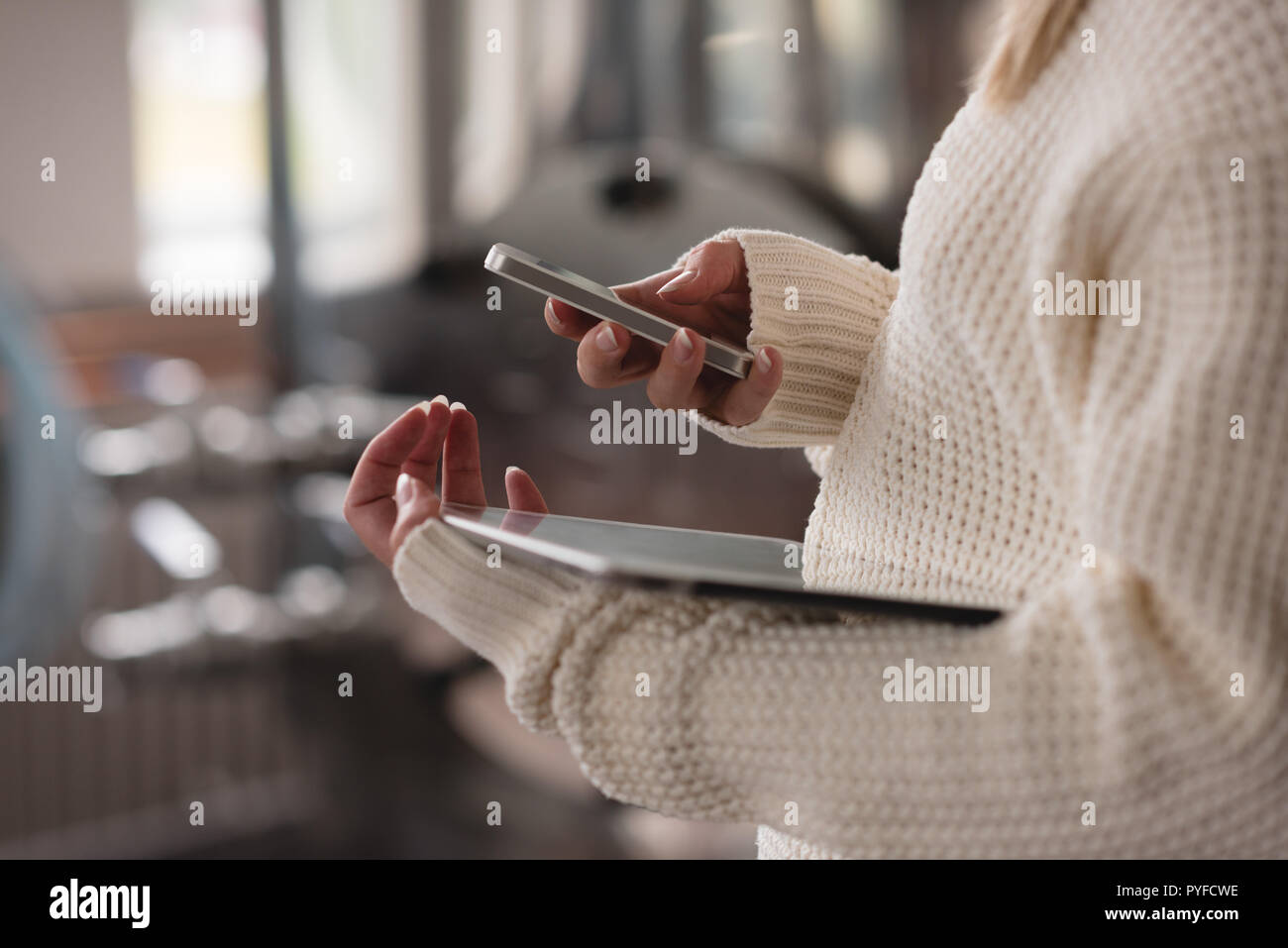 Female worker using mobile phone in factory Stock Photo