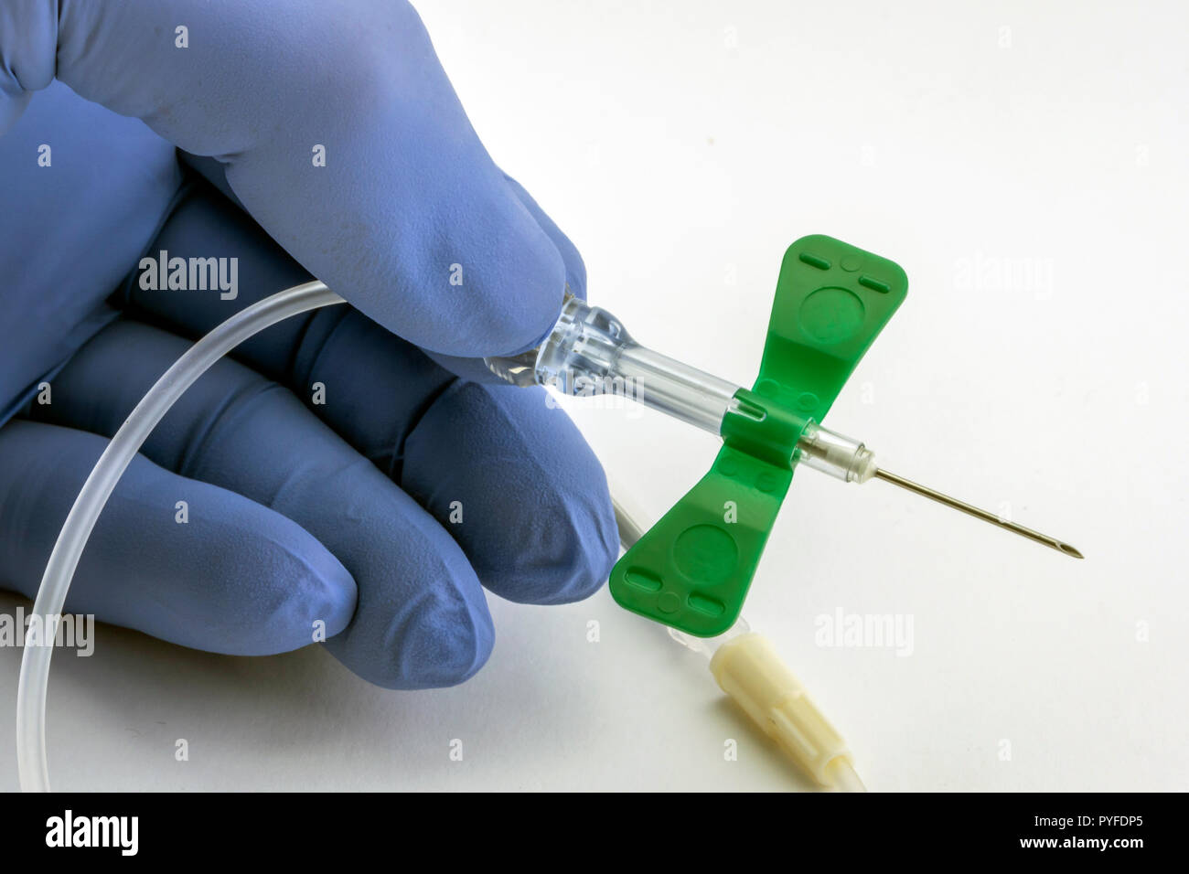 Nurse holds needle butterfly type isolated on white background, conceptual image Stock Photo