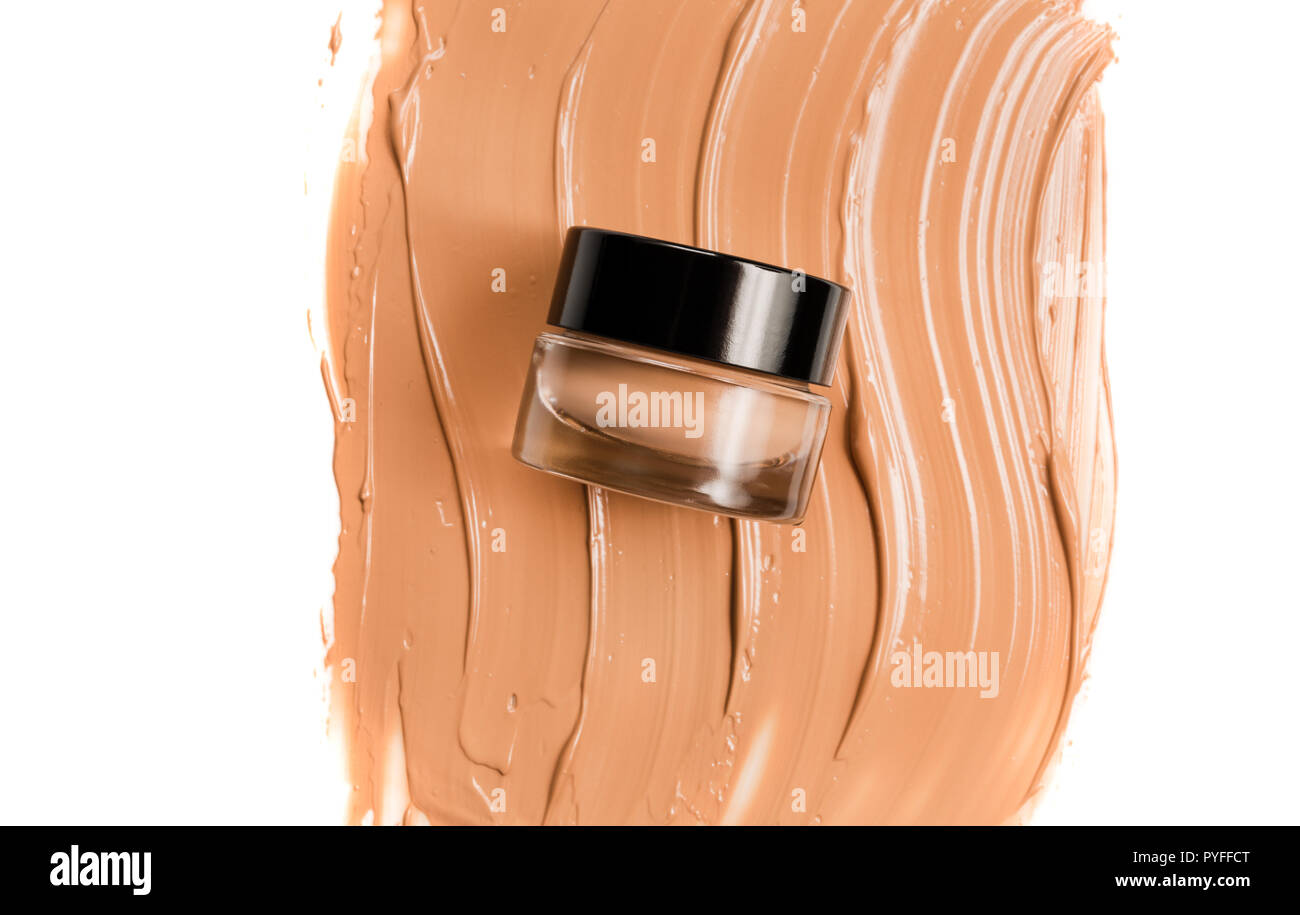 A glass jar of foundation for a face with a sample of the product itself. Cosmetic concept. Stock Photo