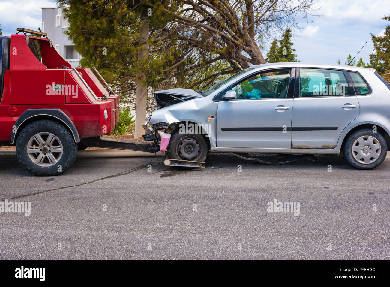 Crashed car after accident ready to be tow away by tow truck Stock Photo
