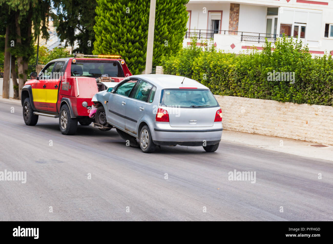 Crashed car being towed away by tow truck after accident Stock Photo