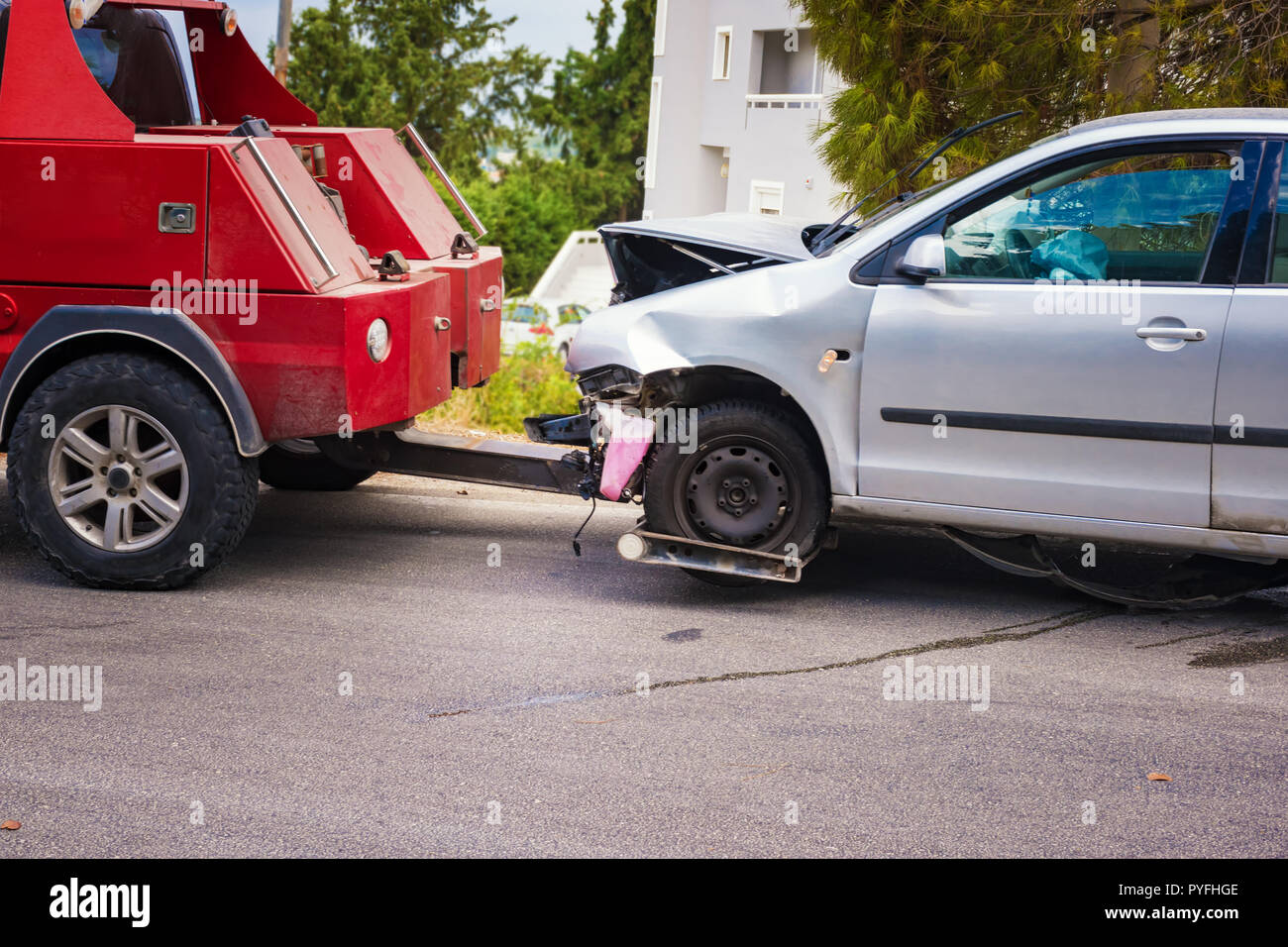Crashed car after accident ready to be tow away by tow truck Stock Photo