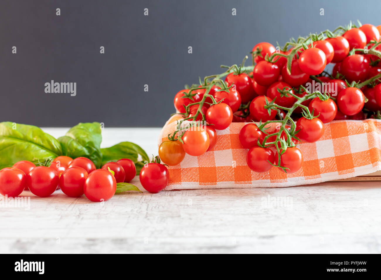 Cherry tomatoes on the Vine With Basil Leaves Stock Photo - Alamy