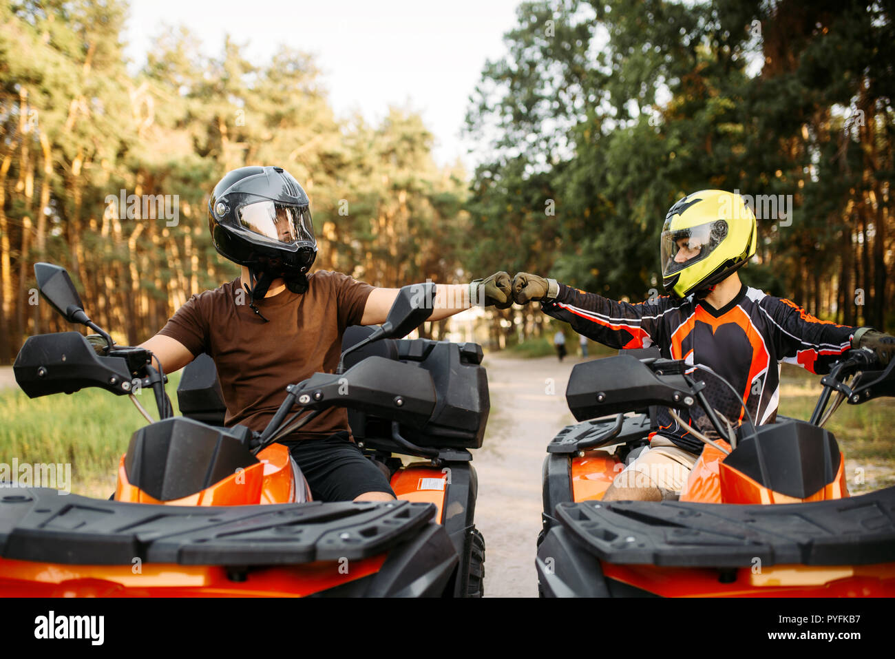 Two Atv Riders In Helmets Hits Fists For Good Luck Before Dangerous Extreme Offroad Riding Front View Summer Forest On Background Freeriding On Qua Stock Photo Alamy