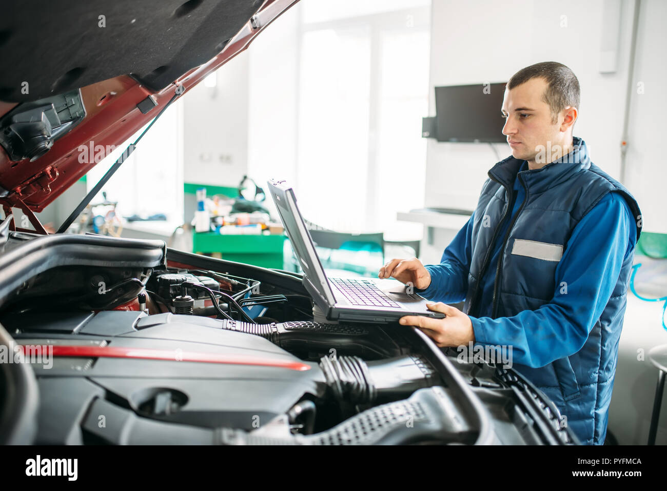 Engineering Car Inspection Engineer makes computer diagnostics of the car in autoservice. Vehicle ...