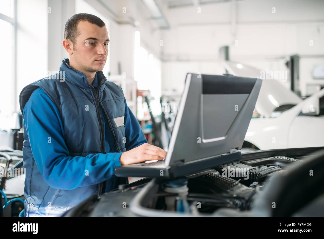 Engineering Car Inspection Engineer makes computer diagnostics of the car in auto service. Vehicle ...