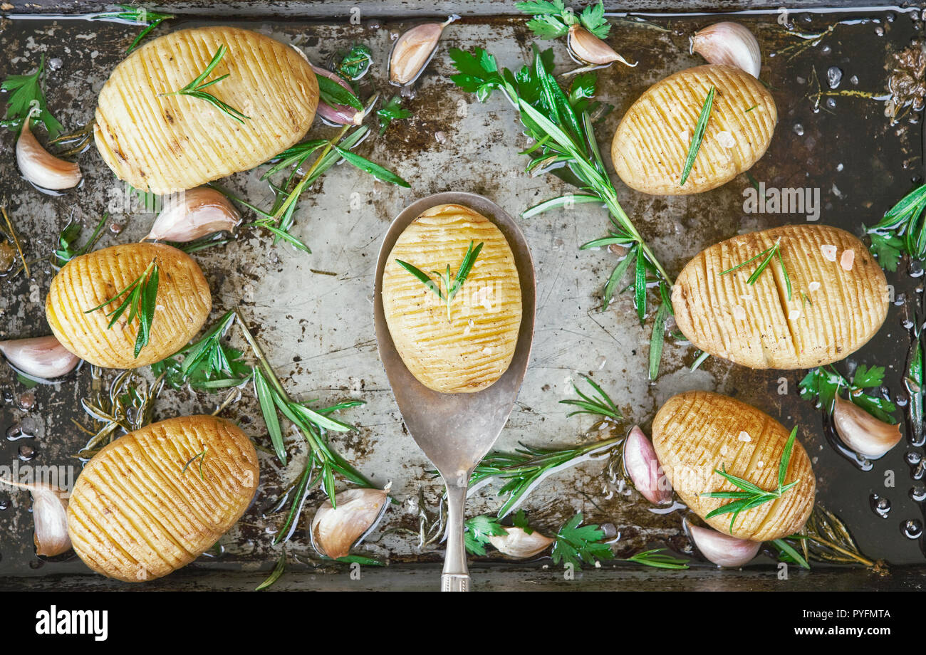 Homemade cheesy Hasselback potatoes. Vegetarian food Stock Photo