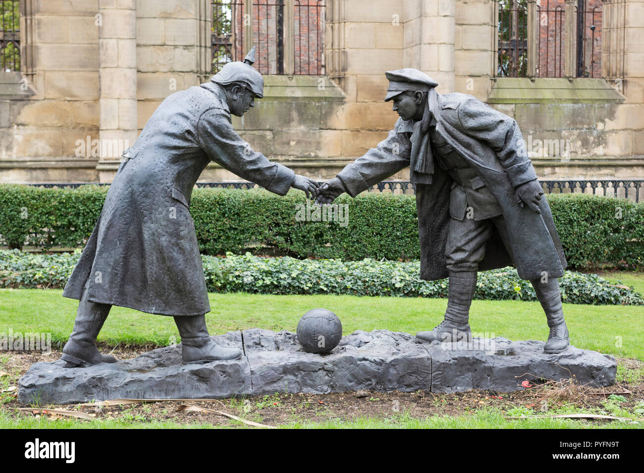 “All together now” statue by Andy Edwards, World War 1 Christmas truce when soldiers played football. St Luke's 'Bombed Out' Church, Liverpool, UK Stock Photo