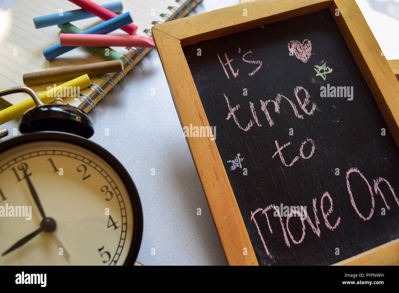 It's time to move on phrase colorful handwritten on chalkboard, alarm