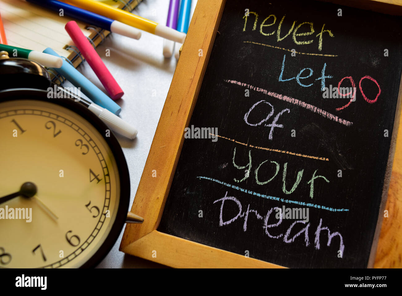 Never let go of your dream on phrase colorful handwritten on chalkboard
