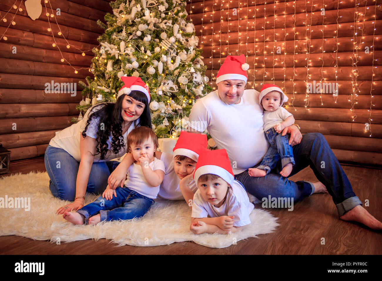 A large happy family gathered at home under the Christmas tree