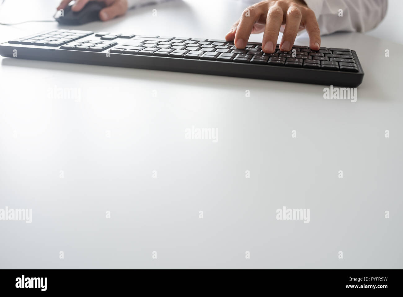 Businessman using computer keyboard and a mouse, with copy space. Stock Photo