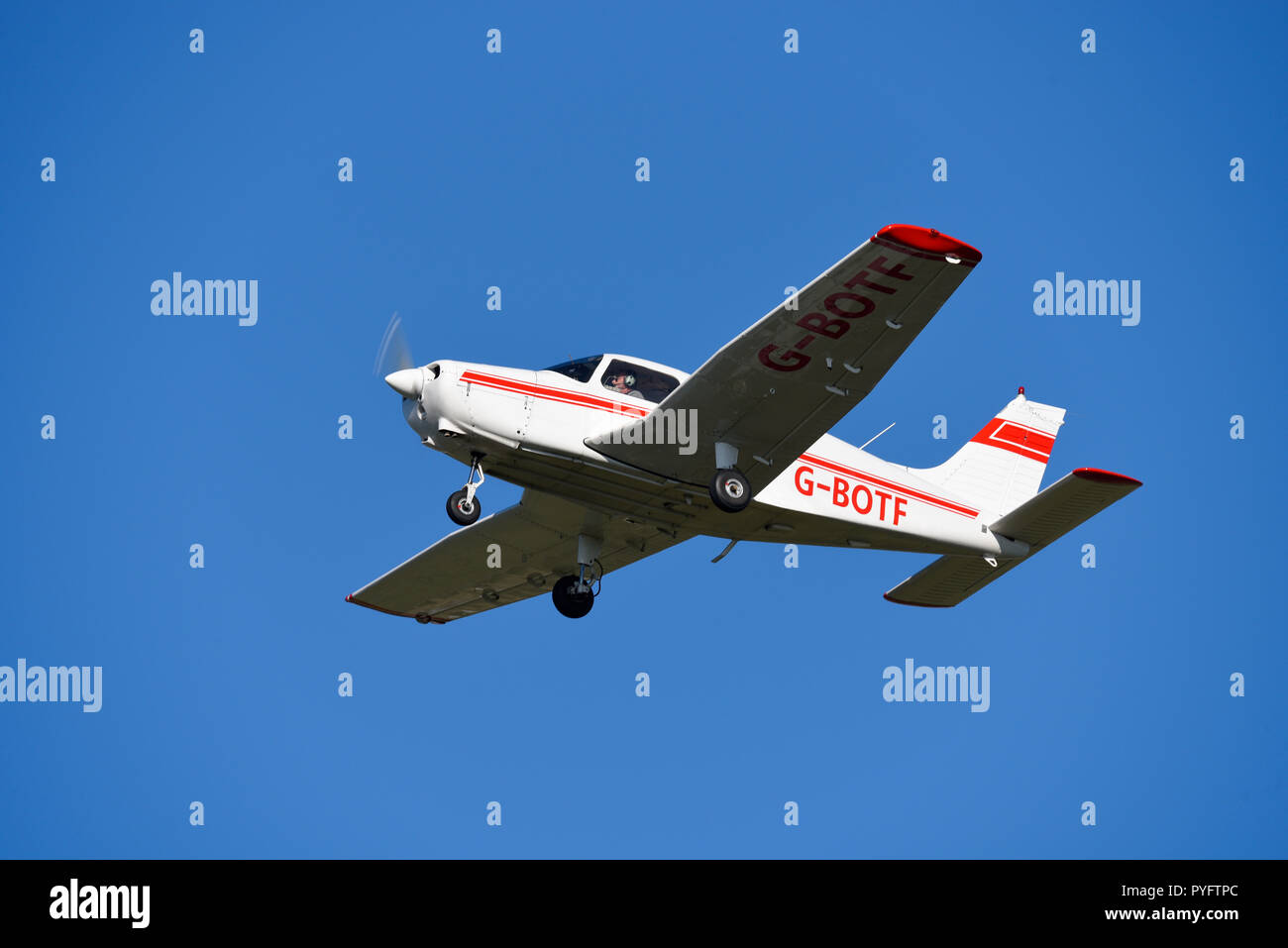 Piper PA-28 Cherokee Warrior light aircraft plane. General aviation airplane flying in clear blue sky. G-BOTF. Good visibility visual flight rules Stock Photo