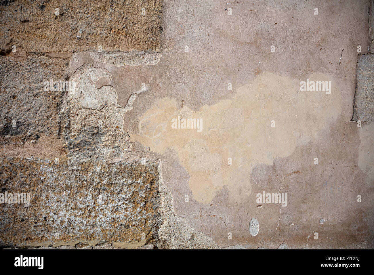 Faded plastered and stone masonry wall, texture grunge background. Stock Photo