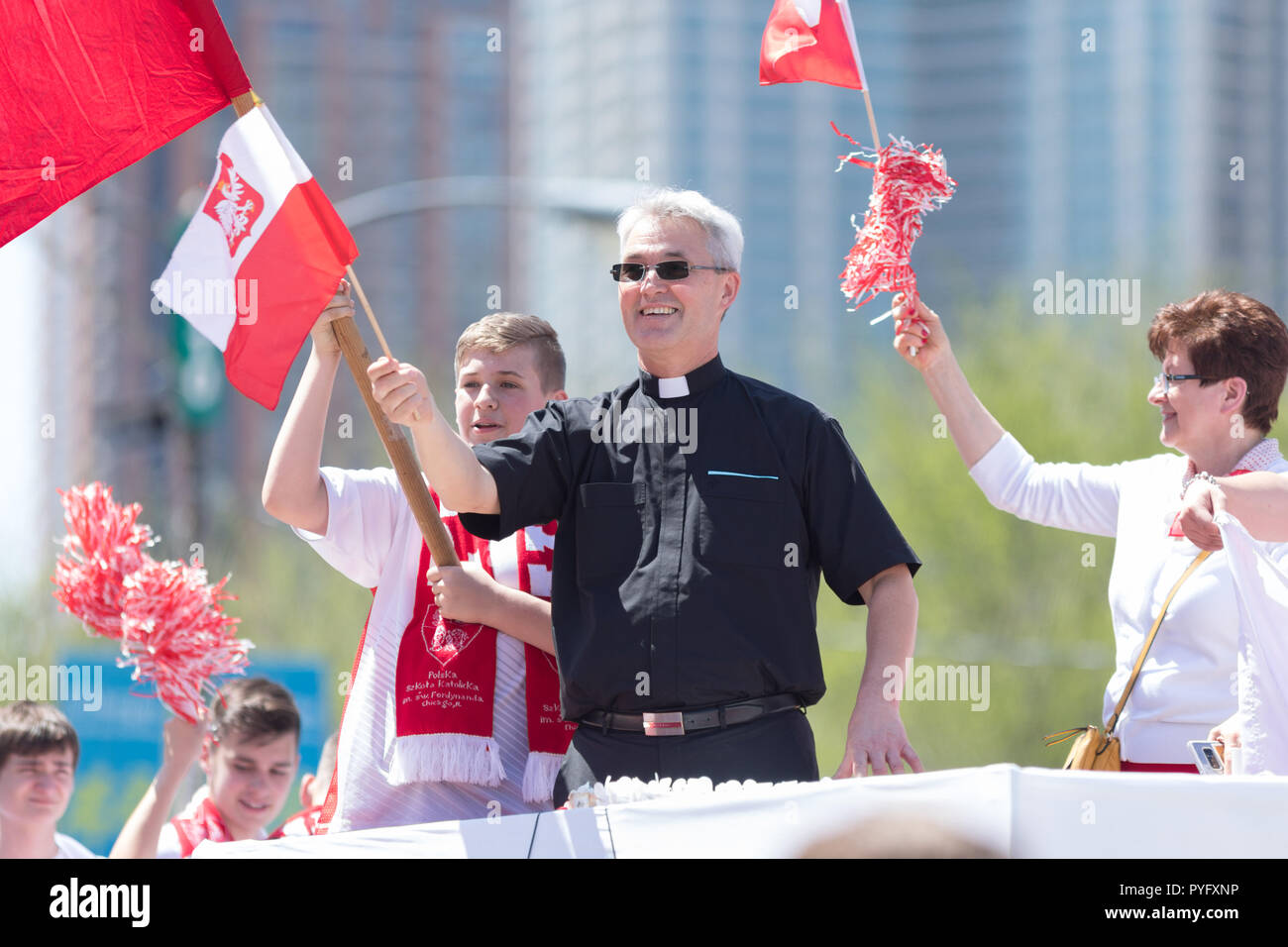 Chicago, Illinois, USA - May 5, 2018: The Polish Constitution Day Parade, Polish catholic priest waving the polish flag during the parade Stock Photo