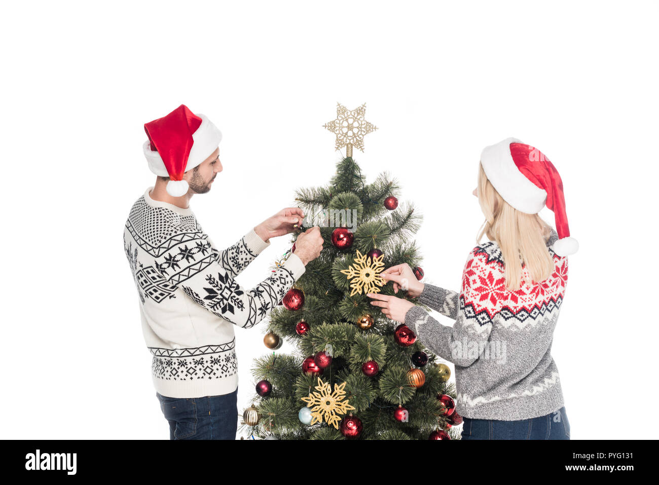 back view of girlfriend and boyfriend in sweaters decorating christmas tree together isolated on