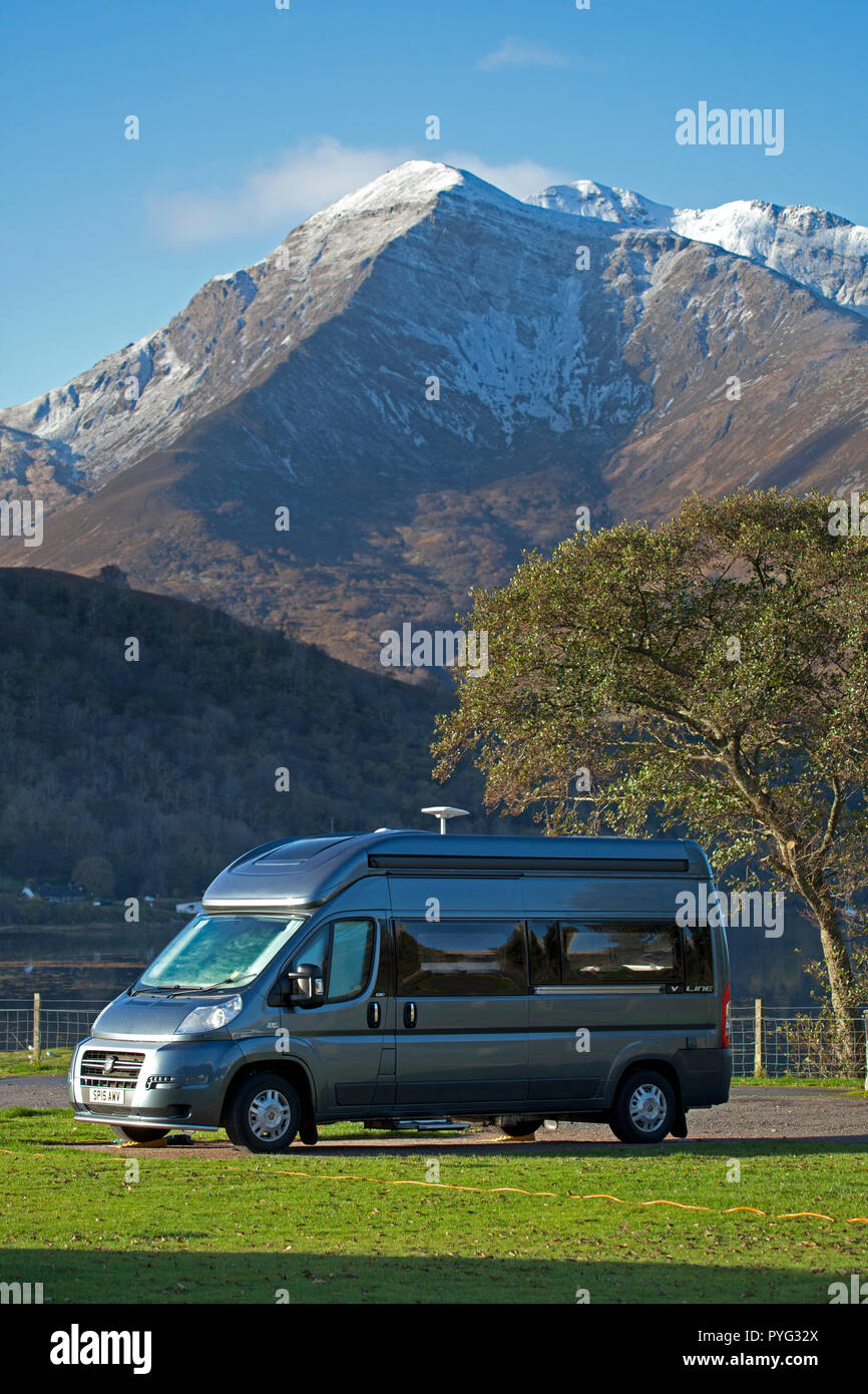 Campervan, Glen Coe, Lochaber, Scotland, UK. 27 Oct. 2018. UK weather, sunshine in the Scottish Highlands after 0 degrees overnight, first dusting of snow on the mountain  tops of Glencoe this autumn, camper van at Invercoe, Stock Photo
