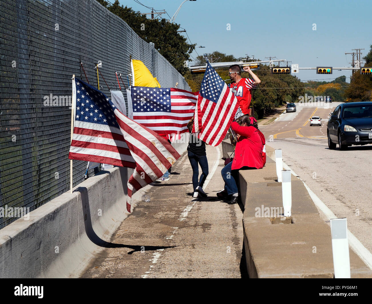 Half-dozen demonstrators of the conservative group calling themselves as 'Overpass for America' strive to call attention to Republican candidates. Seeing a big lead for re-electing Texas governor, they focus on U.S. senate race between Ted Cruz and Beto O'Rourke. Overpass in Arlington Texas near Fort Worth, overlooking Interstate highway I-20.On the overpass David Stained, of Fort Worth, Texas says this is the third weekend they have demonstrated from an overpass and plan on doing it again in Fort Worth next weekend. Semi's and autos honk support for the demonstrators. Stock Photo