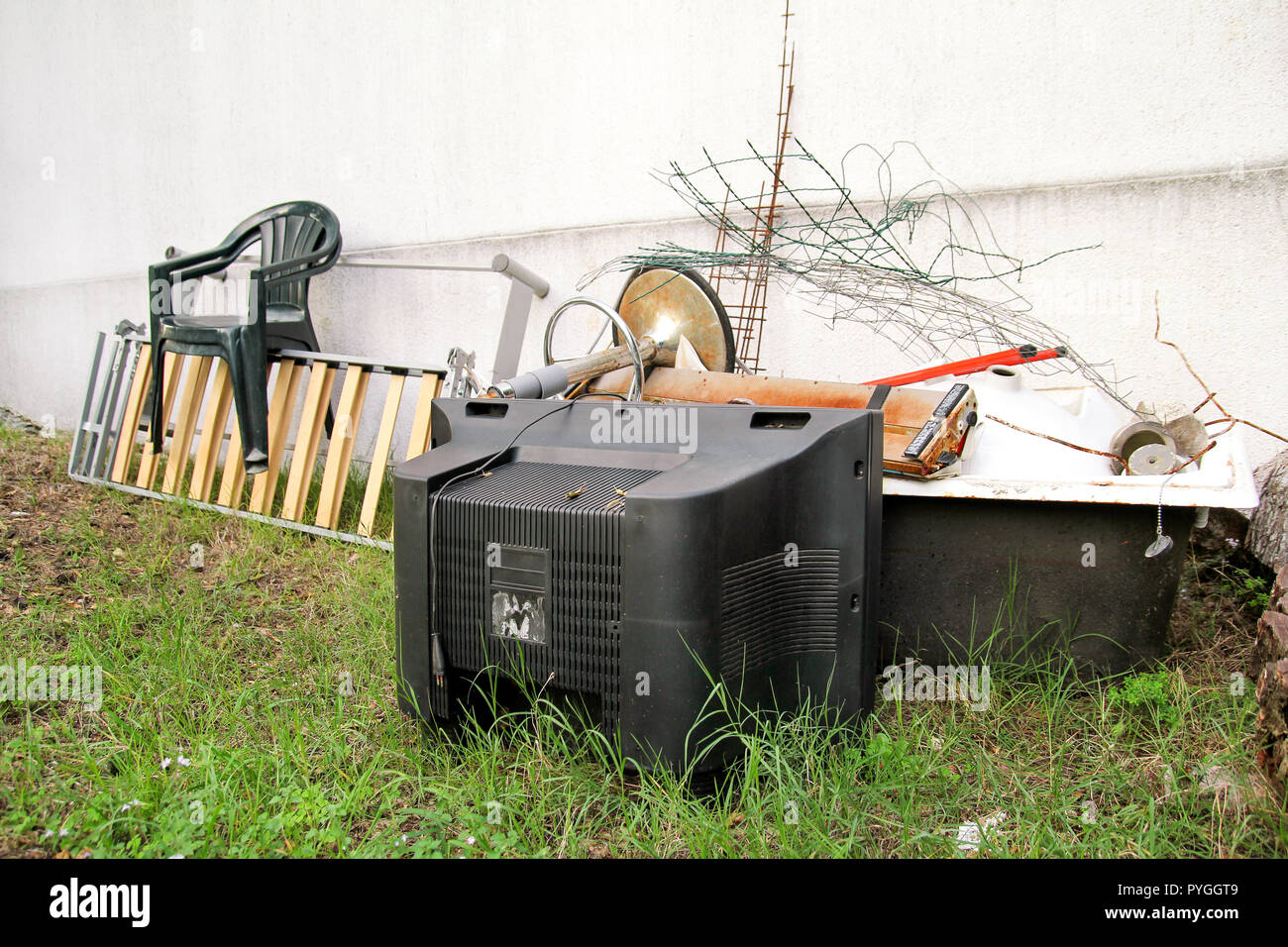 Old TV set and the rest of bulky trash. Old TV thrown away next to a