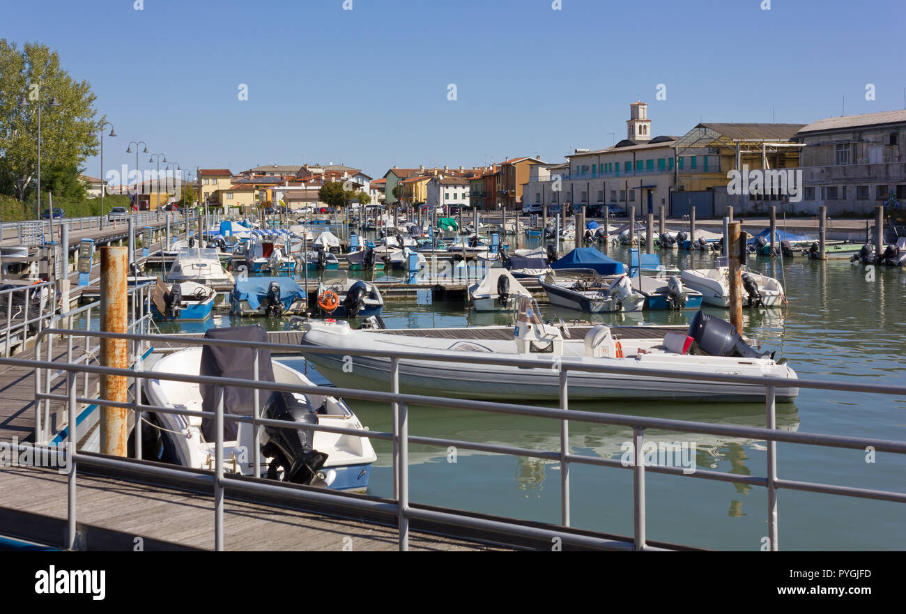 View of a marina in Marano Lagunare, Italy, with the church bell tower in the background Stock Photo