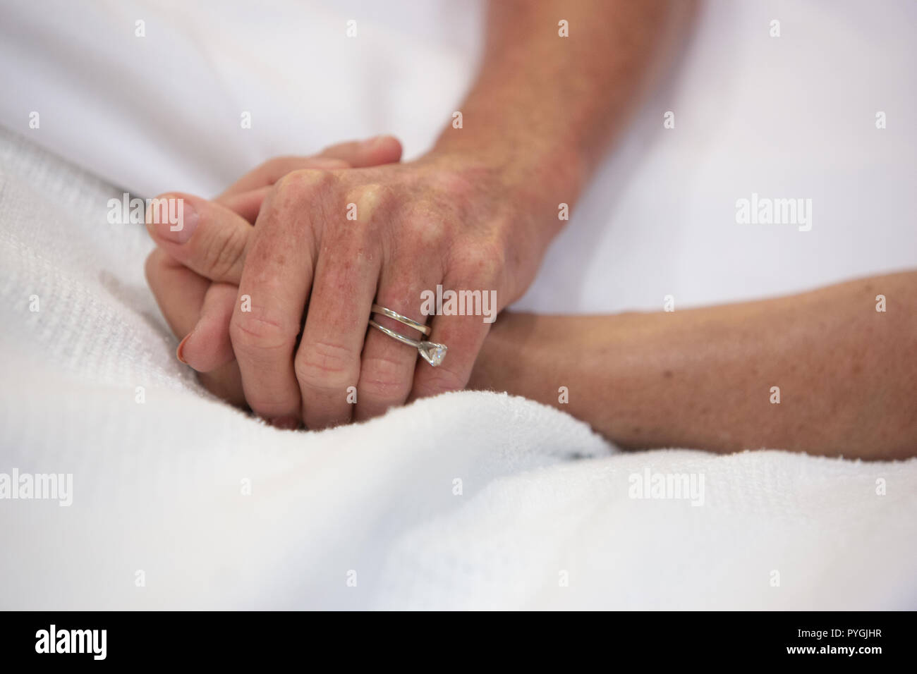 Nurse holds the hand of a hospice patient. Stock Photo